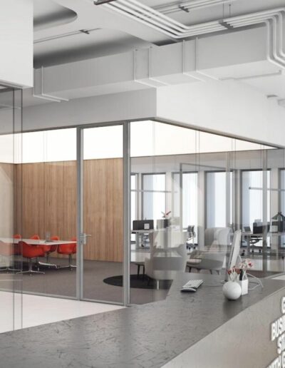 Mamparas en una oficina con sala de reuniones independiente y mesas en espacio compartido