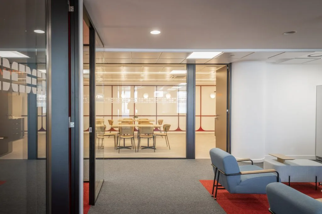 Mamparas de oficina en Madrid: sala de reunión acristalada de suelo a techo con vinilo de señalización y perfilería oscura